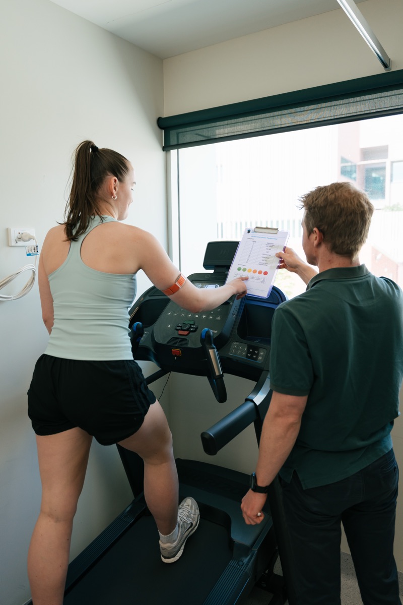 A physiotherapist guiding a graded treadmill exercise test